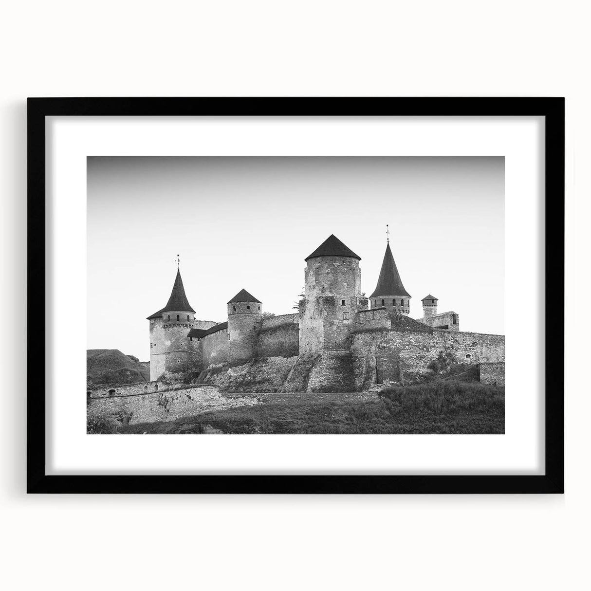 Framed wall art showcasing a picturesque castle landscape design, featuring a sleek black frame and white mat, perfect for enhancing home decor aesthetics.