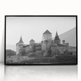 Framed wall art showcasing a stunning landscape of a castle, featuring intricate details and vibrant colors, displayed in a sleek black frame, perfect for home decor.
