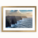 Framed landscape wall art showcasing dramatic cliffs and serene ocean views, accented with a gold mat, ideal for adding elegance to modern decor.