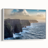 Framed canvas wall art showcasing a serene landscape of dramatic cliffs and vibrant skies, displayed in a stylish white frame, enhancing modern decor.