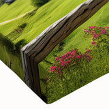 Close-up of a stretched canvas artwork showcasing a serene countryside landscape with vibrant green hills, fluffy white clouds, and a warm blue sky, ideal for home decor.