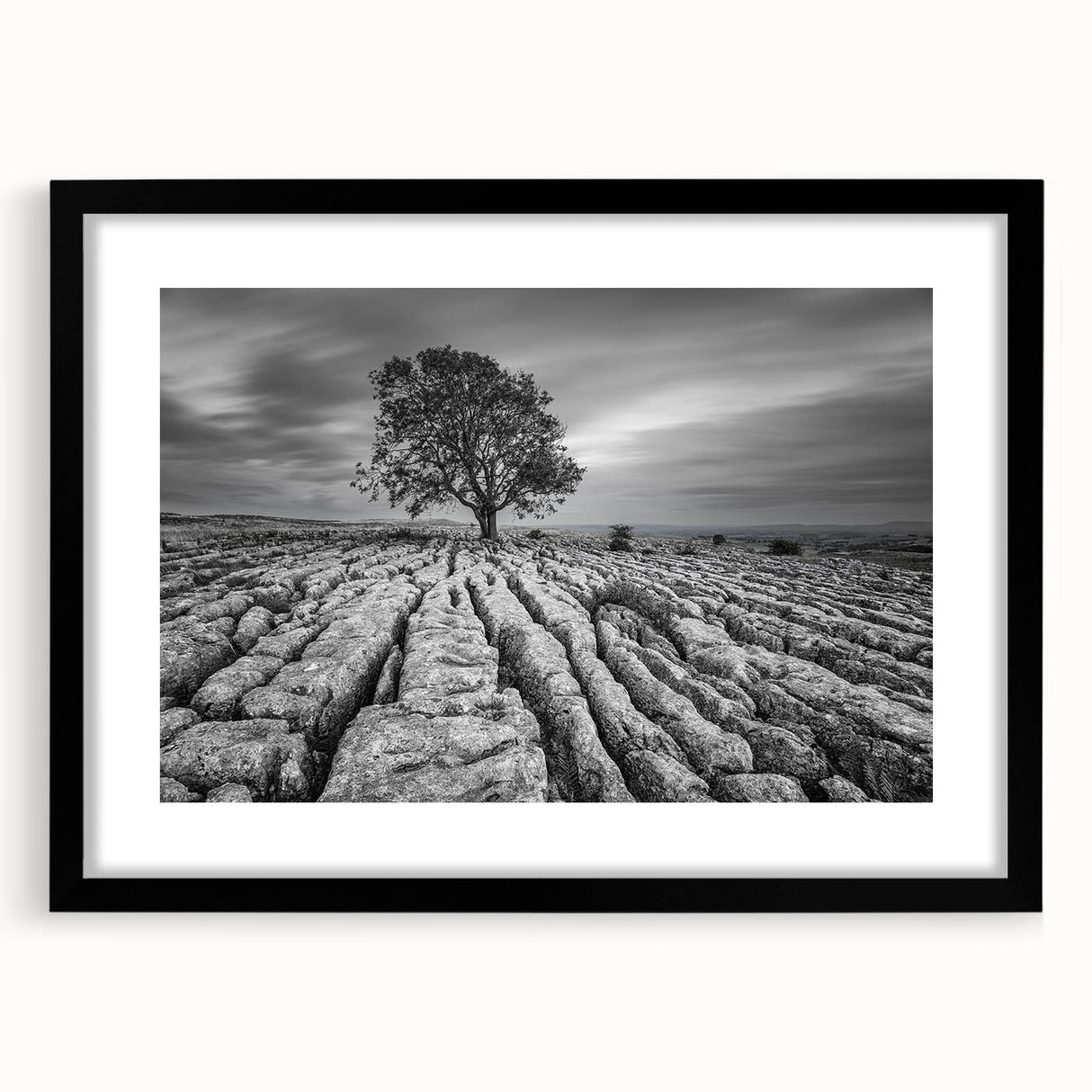 Framed wall art design showcasing a serene countryside landscape, featuring vibrant greens and soft blues, presented in a sleek black frame with a mat for an elegant touch. Perfect for home decor enthusiasts seeking to enhance their living space with nature-inspired artwork.