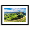 Framed black wall art showcasing a serene countryside landscape, featuring vibrant greenery and rolling hills, ideal for home decor and elegant interiors.