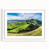 Framed landscape wall art showcasing a serene countryside scene with lush greenery and a vibrant sunset, elegantly matted and perfect for home decor.