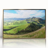 Framed wall art featuring a scenic countryside landscape design with vibrant colors, gold accents, and a sleek acrylic front, ideal for home decor.