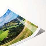 Rolled print of a serene countryside landscape featuring rolling hills and a vibrant sunset, showcasing rich greens and warm oranges, ideal for home decor.