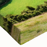 Close-up of a stretched canvas wall art piece depicting a vibrant countryside landscape, featuring rolling hills, lush greenery, and a serene sky, ideal for home decor.