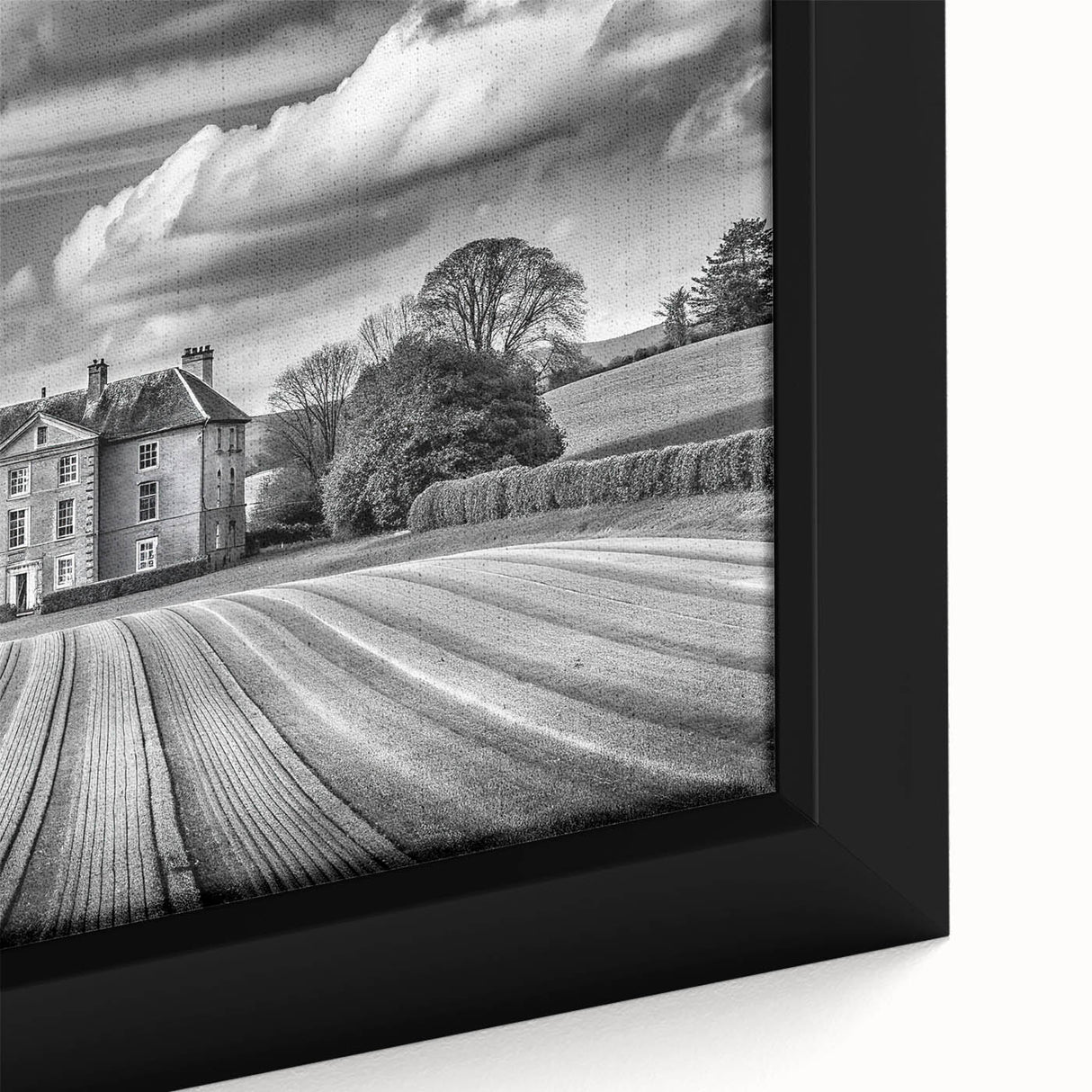 Close-up of a framed canvas artwork showcasing a serene countryside landscape, featuring lush green fields, rolling hills, and a vibrant sunset. Ideal for home decor.