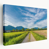 Stretched canvas wall art showcasing a serene countryside landscape with vibrant greens and blues, ideal for enhancing home decor and creating a tranquil atmosphere.
