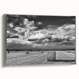 Framed canvas wall art showcasing a serene countryside landscape with vibrant green fields and a cloudy sky, elegantly displayed with silver accents.