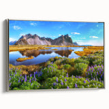 Framed canvas wall art depicting a serene countryside landscape, featuring vibrant green fields and a clear blue sky, with elegant silver framing for a modern touch.
