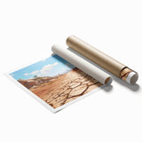 Desert landscape wall art print showcasing vibrant orange and yellow hues, depicting rolling sand dunes under a bright blue sky, elegantly rolled for easy display.