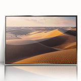 Framed acrylic wall art featuring a serene desert landscape with rolling dunes, showcased in a sleek silver frame, perfect for modern decor.