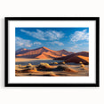 Framed wall art featuring a serene desert landscape with rolling dunes, presented in a sleek black frame with a white mat, ideal for modern home decor.