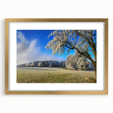 Framed wall art featuring a serene landscape of golden fields under a clear blue sky, with a sleek gold frame and white matting, perfect for home decor.