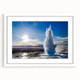 Framed wall art featuring a serene landscape with a geyser, set against a white mat, perfect for enhancing home decor. Ideal for nature enthusiasts and modern interiors.