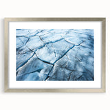 Framed wall art showcasing a stunning glacier landscape in vibrant blues and whites, featuring a sleek silver frame with a mat, ideal for modern home decor.