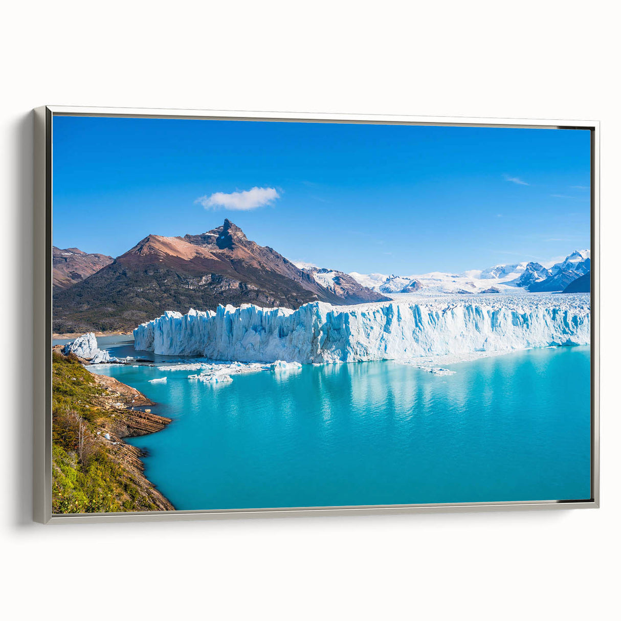Framed canvas wall art showcasing a stunning glacier landscape design, featuring cool blue and white tones, elegantly displayed from a side view with a silver frame. Perfect for adding a serene, nature-inspired touch to any room.