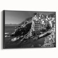 Framed canvas wall art showcasing a serene harbor landscape design, featuring vibrant blues and greens. The artwork is displayed in a sleek black frame, enhancing its visual appeal. Perfect for adding a touch of tranquility to modern home decor.