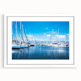 Framed wall art showcasing a serene harbor landscape with soft blue and green hues, elegantly matted in white, ideal for enhancing home decor.