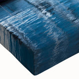 Close-up of a vibrant stretched canvas artwork depicting a serene harbor landscape, featuring calming blues and greens, perfect for enhancing modern home decor.