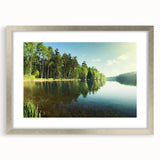 Framed wall art featuring a serene landscape lake design, encased in a silver frame with a mat, perfect for enhancing home decor and creating a calming atmosphere.