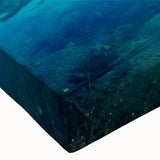 Close-up of a stretched canvas wall art piece depicting a serene lake landscape, featuring vibrant blues and greens, perfect for enhancing home decor.