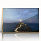 Framed wall art showcasing a coastal landscape with a lighthouse, gold accents, and vibrant colors against a serene sky, perfect for home decor enthusiasts.