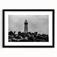 Framed landscape wall art featuring a serene lighthouse design with vibrant colors, black matting, and a sleek black frame, perfect for coastal-themed decor.
