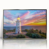 Framed wall art featuring a stunning lighthouse design set against a serene landscape, with a silver-acrylic front that enhances the vibrant colors and details, perfect for coastal-themed decor.