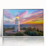 Framed wall art featuring a serene lighthouse design against a vibrant landscape, showcasing calming blues and greens, perfect for coastal-themed decor.