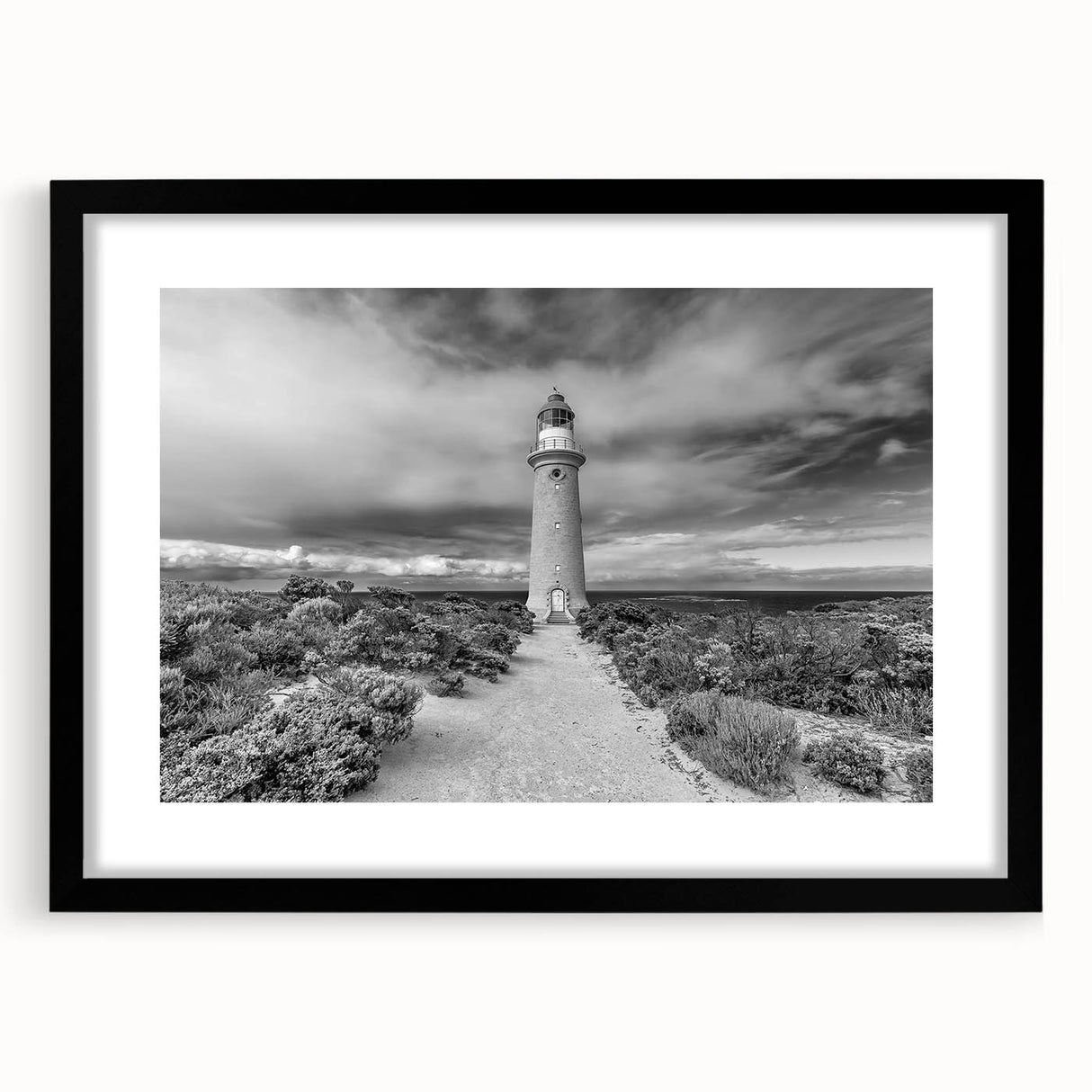 Black framed wall art collection featuring vibrant landscapes and a lighthouse design, ideal for home decor, enhancing coastal-themed interiors with a modern touch.