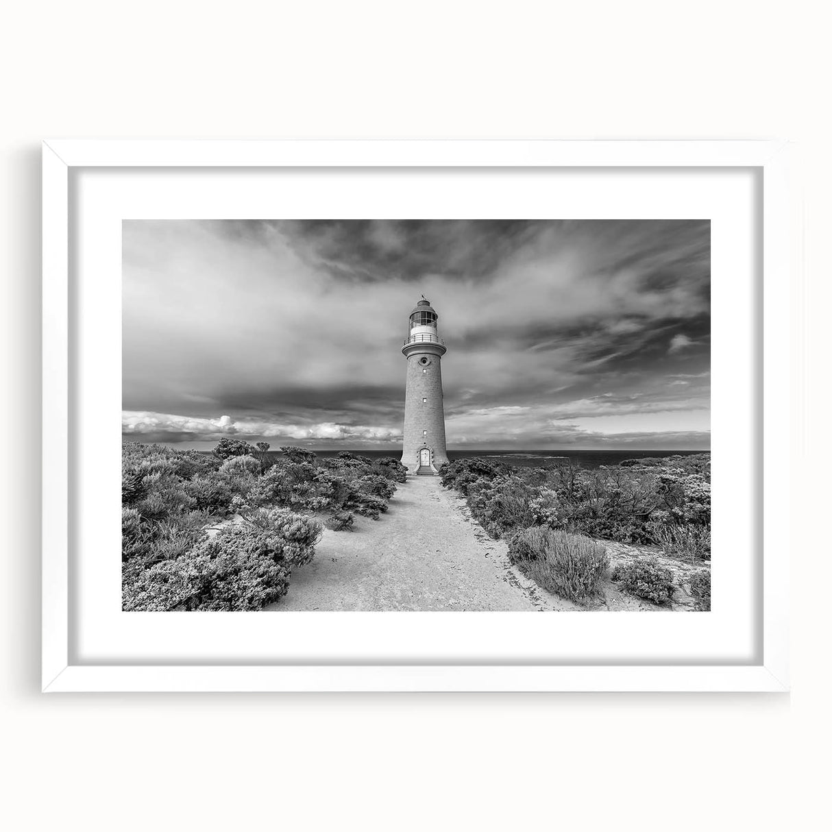 White-framed wall art collection showcasing a serene lighthouse landscape design with a mat, perfect for coastal decor enthusiasts looking to enhance their space.