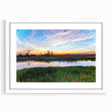 Framed wall art depicting a serene marsh landscape, featuring lush greenery and reflective water, presented in a white mat for an elegant finish. Ideal for nature-themed decor.