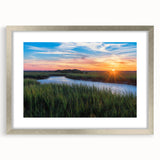 Framed wall art showcasing a serene marsh landscape design with vibrant greens and soft blues, complete with a silver mat and frame, perfect for home decor enhancement.