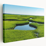 Stretched canvas wall art depicting a serene marsh landscape with vibrant greens and soft blues, showcasing reflections in water, perfect for nature lovers.