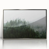 Framed wall art featuring a serene misty landscape design in soft gray and blue tones, showcasing nature's tranquility with a sleek silver frame, ideal for modern decor.