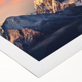 Vibrant rolled canvas artwork depicting a majestic mountain landscape at sunset, showcasing rich colors of orange, purple, and blue, perfect for home decor.