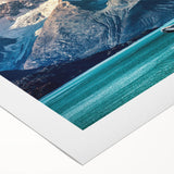 Colorful rolled canvas artwork depicting a serene mountain landscape at sunset, showcasing vibrant hues of orange, purple, and blue, perfect for home decor.