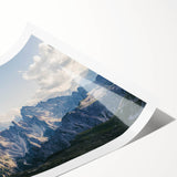 Vibrant wall art print depicting majestic mountains with a blue sky background, rolled and ready for display, perfect for enhancing home decor aesthetics.