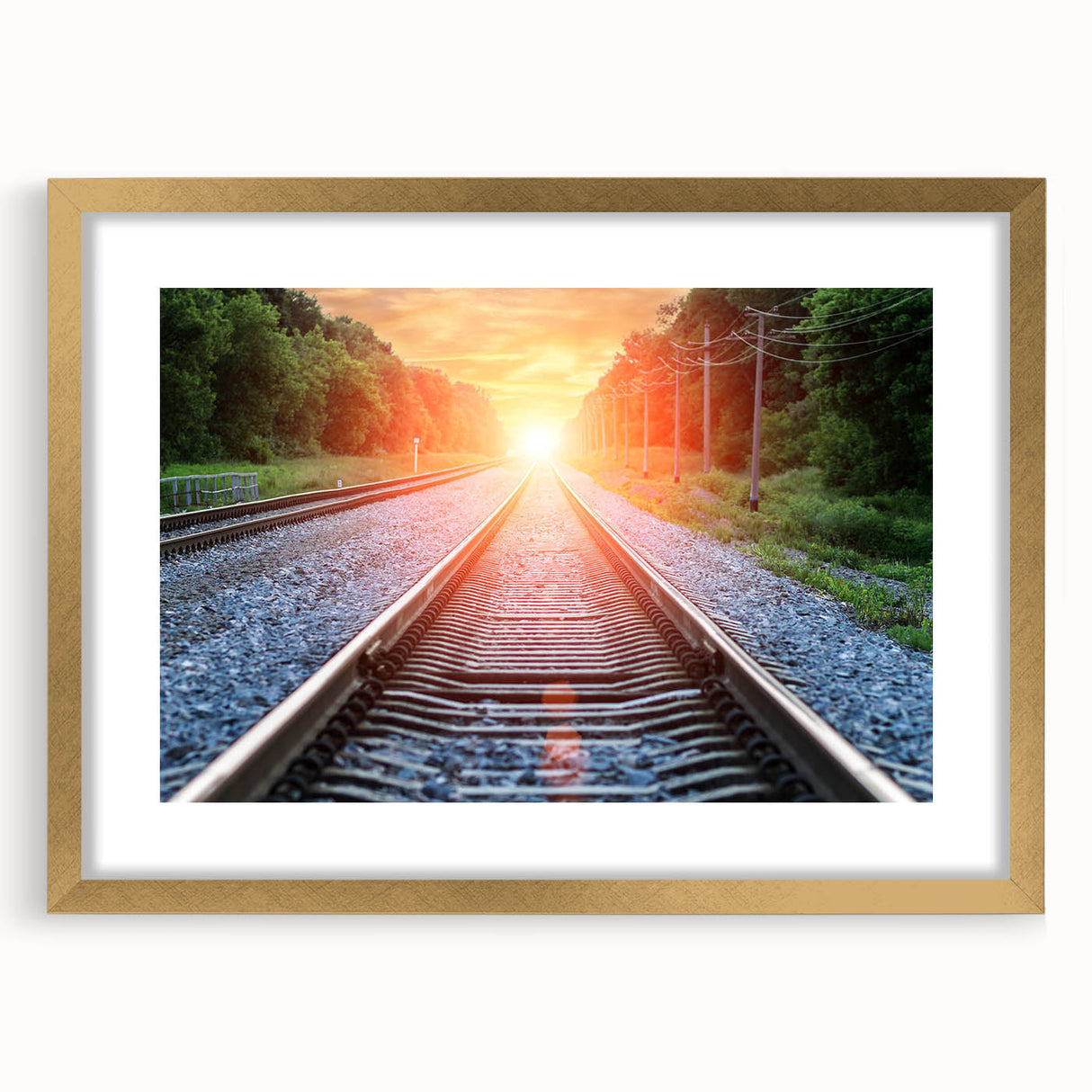 Framed wall art featuring a scenic landscape with railroad tracks, set in a gold frame with a mat, showcasing a serene view of nature and travel. Ideal for home decor enthusiasts.