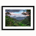 Framed rainforest landscape wall art featuring vibrant greens and earthy tones, designed to enhance home décor with a modern touch and elegant black mat.
