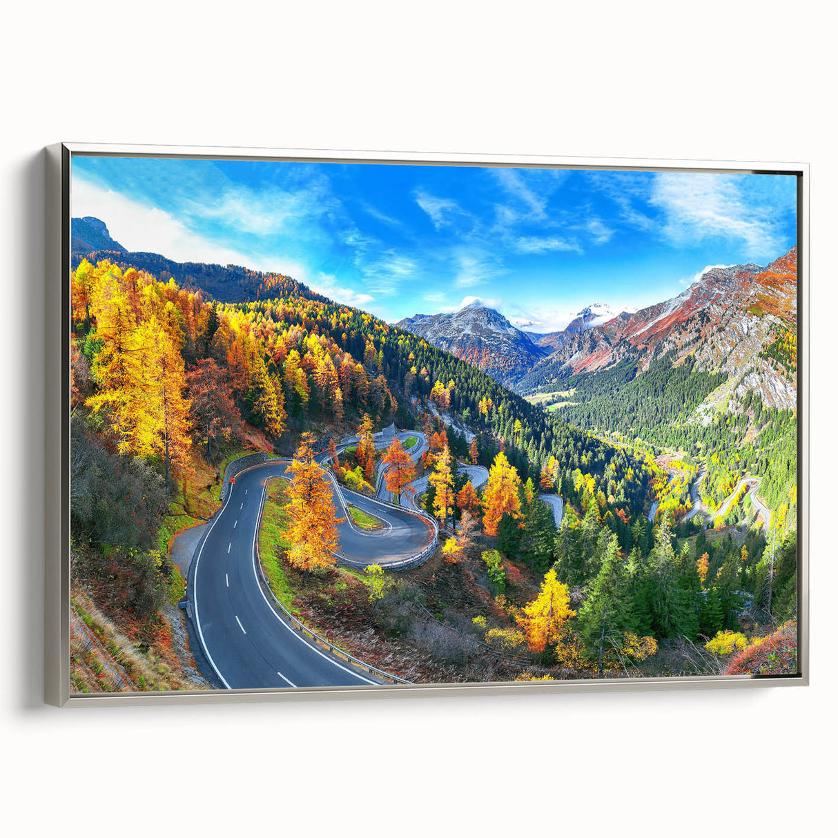 Framed canvas wall art featuring a serene landscape with winding roads and vibrant greenery, elegantly presented with a silver frame, perfect for home decor.