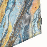 Close-up of an abstract wall art piece featuring a vibrant landscape design with intricate rock formations, printed on acrylic glass for a modern decor style.