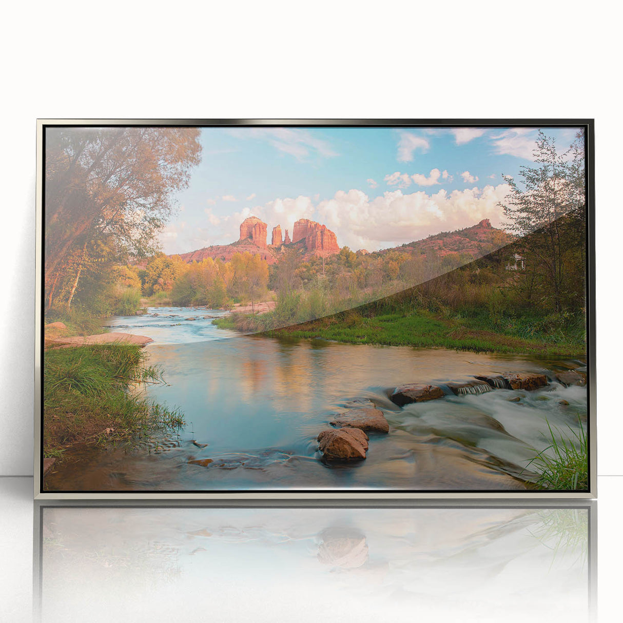 Framed wall art showcasing a minimalist landscape design featuring rocks and natural elements, presented in a sleek silver frame with an acrylic front for a modern aesthetic.