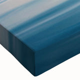Close-up of a vibrant stretched canvas wall art piece featuring serene seascape design, showcasing rich blues and greens, ideal for modern home decor.