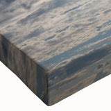 Close-up of a stretched canvas featuring a vibrant landscape design with dramatic sky elements, showcasing rich colors and intricate details, perfect for home decor.