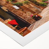 Colorful rolled canvas artwork showcasing a vibrant landscape and street design, ideal for modern home decor, packaged securely in a protective cardboard tube.