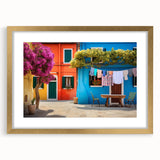 Framed wall art from the Landscapes Streets Design collection featuring a gold mat, showcasing a vibrant street scene with colorful buildings and trees, ideal for modern home decor.