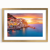Framed wall art featuring a picturesque village landscape design with vibrant colors, set in a gold frame with a mat, perfect for home decor enhancement.
